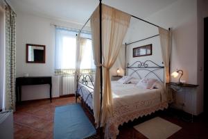 sypialnia z łóżkiem z baldachimem i oknem w obiekcie Il Vecchio Noce w mieście Brugnato