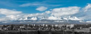 a view of a city with snow capped mountains in the background at Apartman Katka in Poprad
