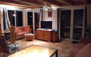 Una sala de estar con un televisor, un sofá y una mesa. en Haus Solvig, en Fehmarn