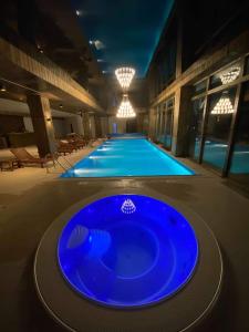 a large swimming pool with a blue tub in a building at New Gudauri Atrium Apartment 202 in Gudauri