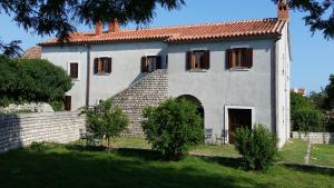 una gran casa blanca con techo rojo en Apartments Stella Apsyrtides en Osor