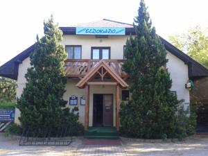 a house with trees in front of it at Eldoradó Fogadó és Kemping in Vonyarcvashegy