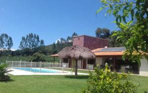 a house with a swimming pool in a yard at Pousada Tia Tuquinha in Piauí
