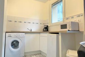 a kitchen with a washing machine and a microwave at A l'Ancre Bleue in Le Tréport