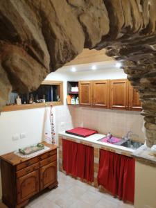una cucina con lavandino e parete in pietra di Antica Cantina Poesia, San Vito Romano a San Vito Romano