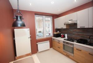 a kitchen with red walls and a white refrigerator at Apartament Golden in Mielec
