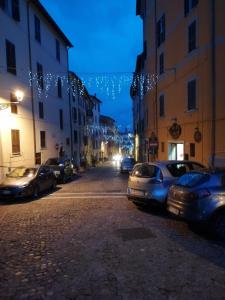 een stadsstraat 's nachts met auto's geparkeerd bij Antica Cantina Poesia, San Vito Romano in San Vito Romano