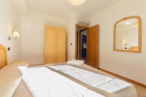 a white room with a mirror and a bed at Le Tartarughe Aparthotel in Letojanni