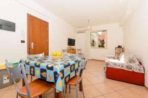 a dining room with a table with a bowl of fruit on it at Le Tartarughe Aparthotel in Letojanni