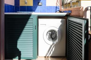 a washing machine under a counter in a bathroom at Le Tartarughe Aparthotel in Letojanni