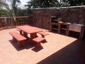 une table de pique-nique et deux bancs sur une terrasse dans l'établissement Bilene Dream House 1, à Vila Praia Do Bilene