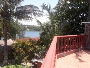 um banco vermelho com vista para uma massa de água em Bilene Dream House 1 em Vila Praia do Bilene