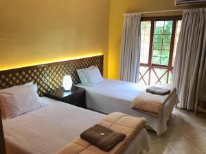 a hotel room with two beds and a window at Bilene Dream House 1 in Vila Praia Do Bilene