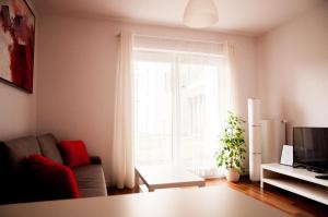 a living room with a couch and a window at Apartament Rosso in Łódź