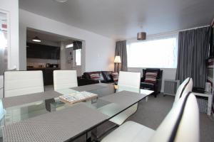 a living room with a glass table and chairs at Southside Apartment Glasgow in Glasgow