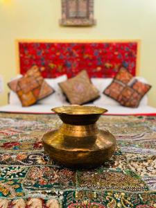 a brass vase sitting on top of a rug at Shanti Home in Jaisalmer