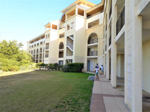 zwei Personen, die vor einem Gebäude spazieren in der Unterkunft Appart du golf in Saint-Jean-de-Monts