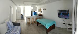ein Wohnzimmer mit einem Tisch und einer Küche in der Unterkunft New Deluxe Sunny Bungalow in Adeje
