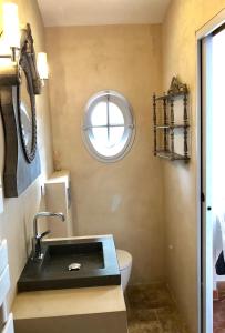 a small bathroom with a sink and a window at Lovely "Provence" villa with sea view, private heated pool, airco and beautiful garden in Grimaud