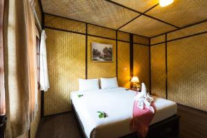 Habitación pequeña con cama con colcha blanca en Nakakiri Resort & Spa, en Hin Dat