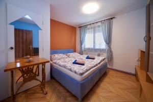 a small bedroom with a bed and a table at Penzion Zajíček in Zaječí