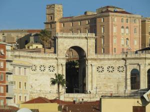 un edificio con un arco en una ciudad en Luna Rossa Rooms, en Cagliari