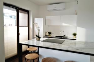 a kitchen with a counter with stools and a sink at Central Port Warsaw Apartment in Warsaw
