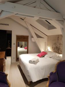 una camera da letto con un grande letto bianco in una stanza di chambre d'hôte Croix-Rousse a Lione