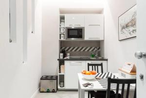 a kitchen with a table with a bowl of oranges on it at Interno 1 Ciampino Roma Luxury Apartment con balcone in Ciampino