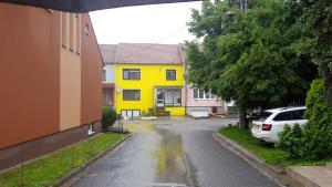 a yellow house on the side of a street at Penzion Zajíček in Zaječí