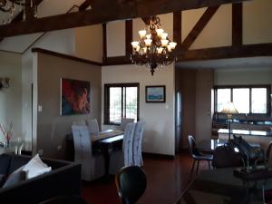 a dining room with a table and chairs and a chandelier at Khumbula Lodge in Underberg