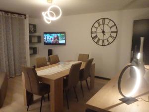 une salle à manger avec une table et une horloge murale dans l'établissement Gîte Les Lilas, à Gérardmer