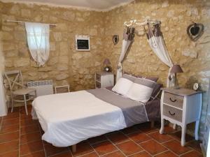 1 dormitorio con 1 cama, 1 mesa y 1 silla en Boubée, en Mas-dʼAuvignon