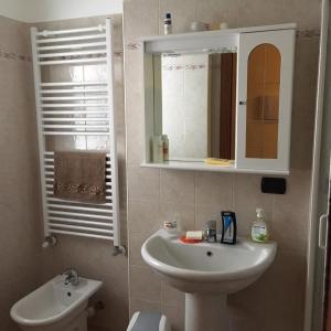 a bathroom with a sink and a mirror and a toilet at La marmotta bianca ski in out- CIR 0370 in Breuil-Cervinia