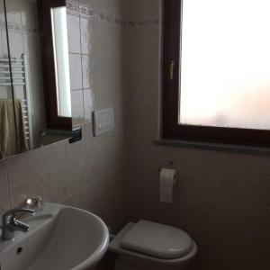 a bathroom with a sink and a toilet and a window at La marmotta bianca ski in out- CIR 0370 in Breuil-Cervinia