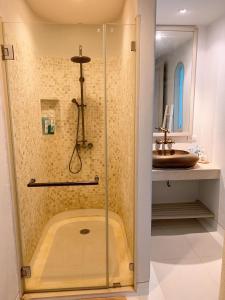 a shower in a bathroom with a sink at Chelona huahin beachfront condominium in Khao Tao