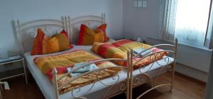 a metal bed with colorful pillows on it at Ferienhaus Roman in Hinterstoder