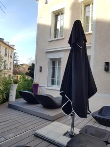 a black umbrella sitting on a patio in front of a building at chambre d'hôte Croix-Rousse in Lyon