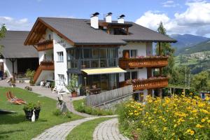 a large house with a balcony and a garden at Oberpalwitterhof in Barbiano