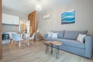 a living room with a blue couch and a table at ANEMOLIA in Agios Ioannis Kaspaka