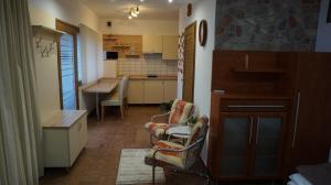 uma cozinha com duas cadeiras e uma mesa em Chloe Apartman em Szigetvár