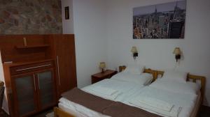 duas camas num quarto com uma fotografia na parede em Chloe Apartman em Szigetvár