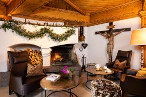 a living room with a fireplace and a christmas tree at Sporthotel Arabba in Arabba