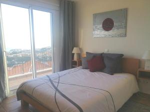 ein Schlafzimmer mit einem Bett und einem großen Fenster in der Unterkunft Casa do Imaculado in Funchal