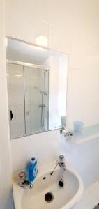 Baño blanco con lavabo y espejo en Wheatsheaf Inn en Ledbury