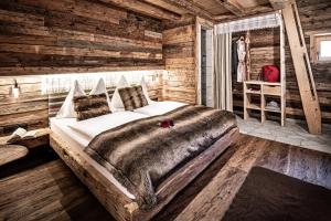 een slaapkamer met een groot bed in een blokhut bij Prechtlgut in Wagrain