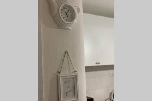 un reloj colgando en una pared junto a una cocina en Servus apartment Ilica, en Zagreb