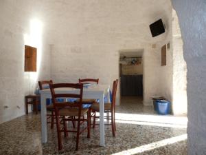 una sala da pranzo con tavolo e sedie bianchi di Il Piccolo Trullo a Cisternino