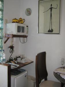 a kitchen with a microwave and a table with a chair at Junior SUITE M&J in Caracas