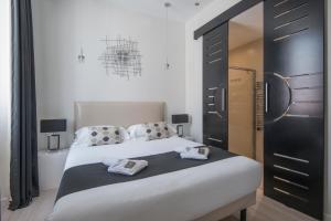 - une chambre avec un grand lit et une armoire noire dans l'établissement O Carré Croisette Cannes, à Cannes